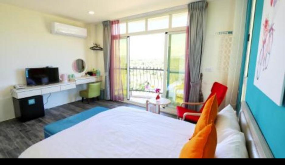 a bedroom with a bed and a large window at Full Moon Resort in Hengchun