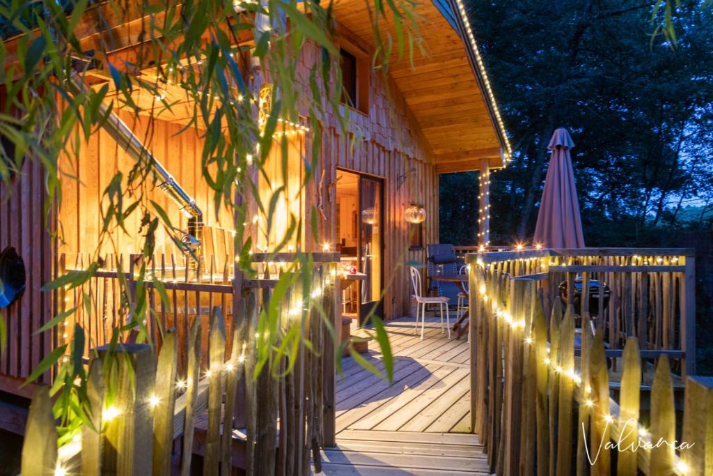 a wooden deck with lights on a house at Les Cabanes du Beau Vallon in Profondeville