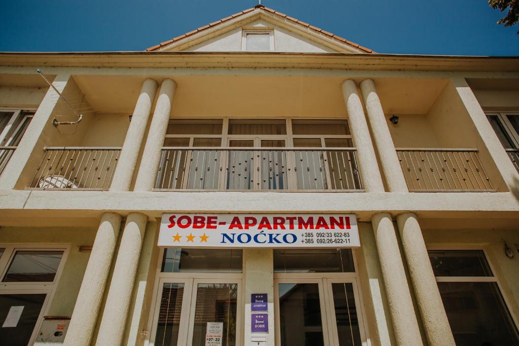 a building with a sign in front of it at Noćko-Sobe i apartmani in Vukovar