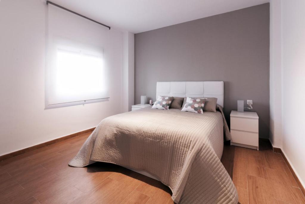 a white bedroom with a bed and a window at Apartamento La Terraza del Mar in Cádiz