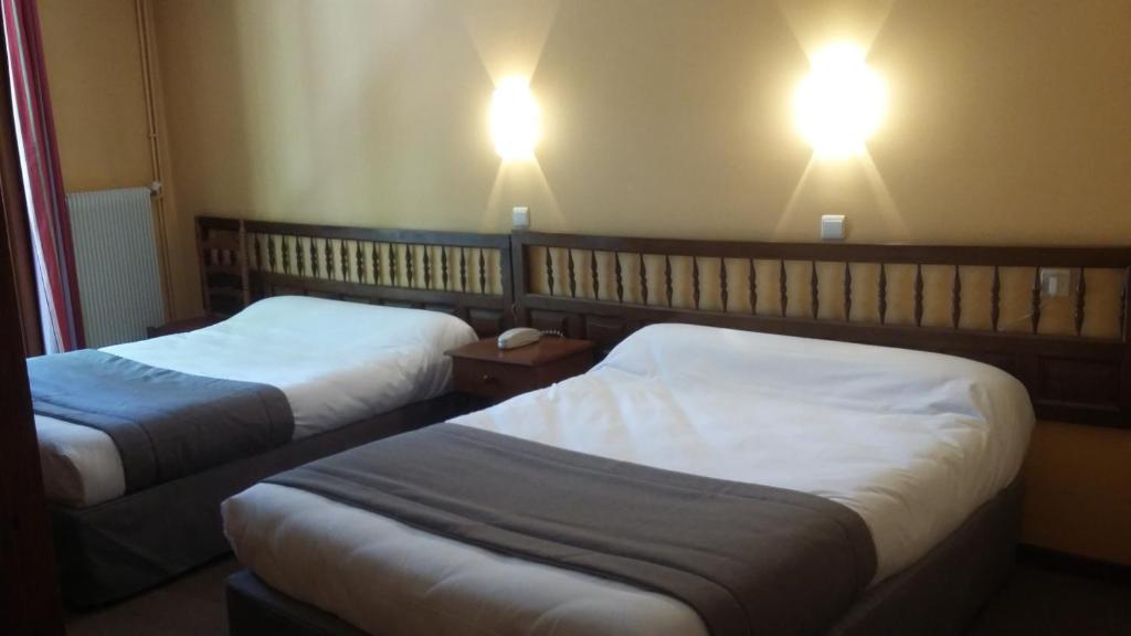 Een bed of bedden in een kamer bij Hotel des Arcades