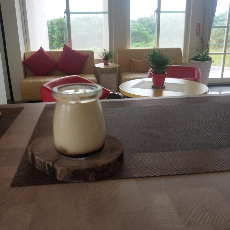 a room with a table with a candle on a wooden coaster at Full Moon Resort in Hengchun