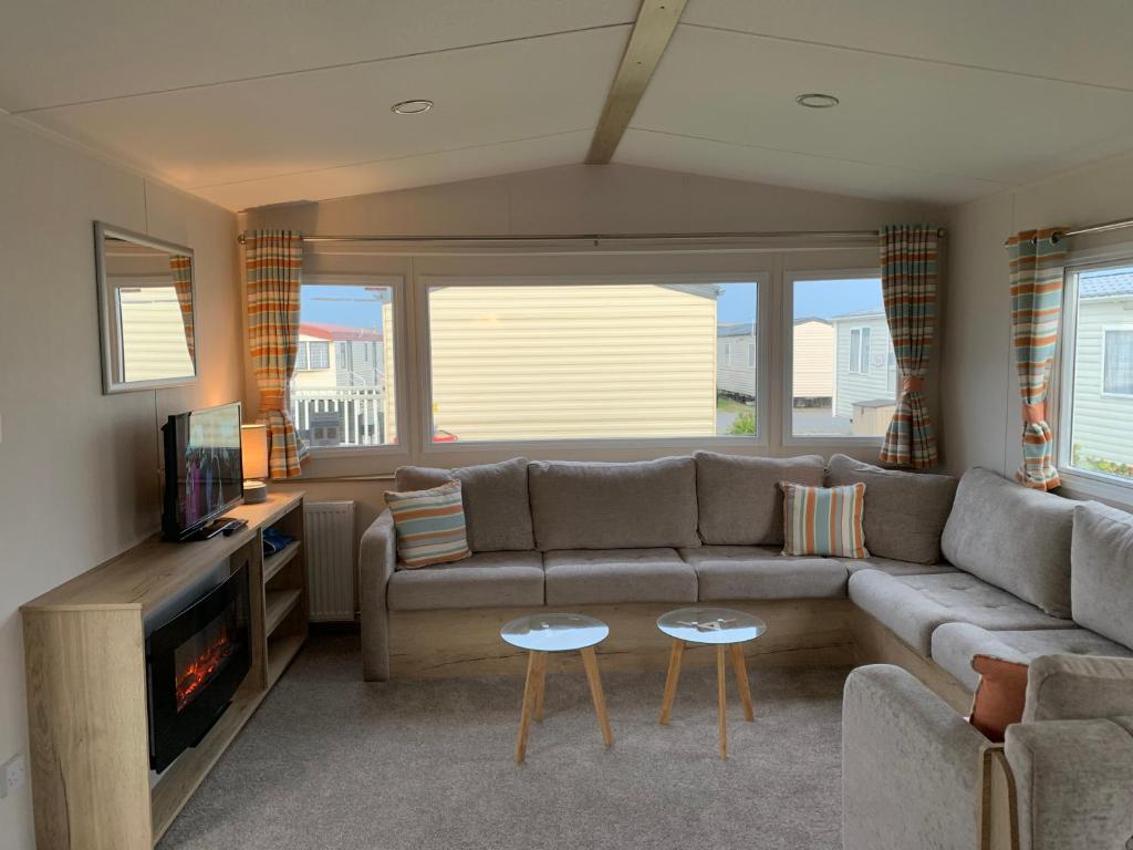 a living room with a couch and a tv at Brambles 66 -Static Holiday Caravan, Porthcawl in Newton