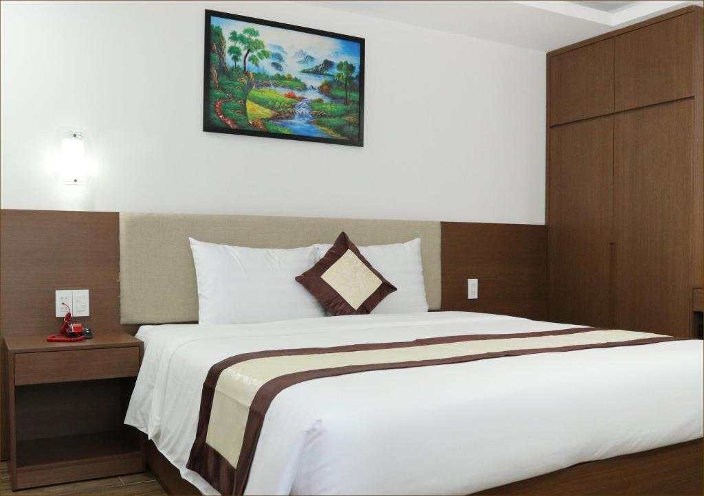 um quarto com uma cama grande e uma imagem na parede em DORADO HOTEL em Nha Trang