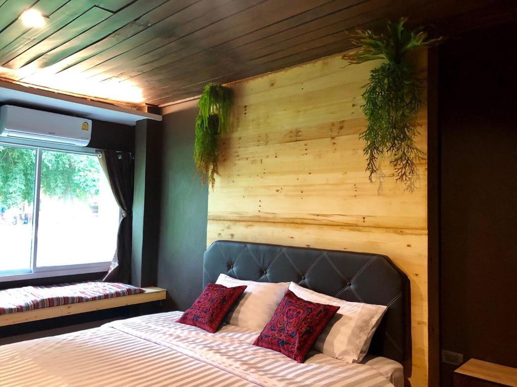 a bedroom with a bed with a wooden wall at Ruankaew Boutique Resort Lampang in Lampang