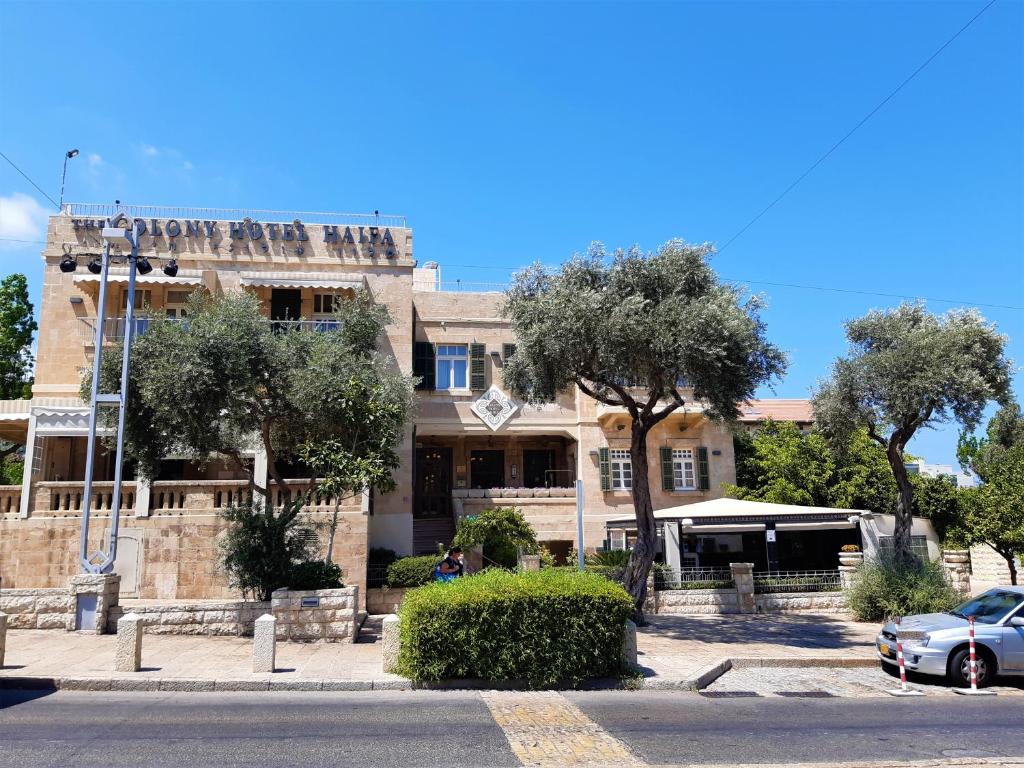 a building with a car parked in front of it at The Colony Hotel in Haifa