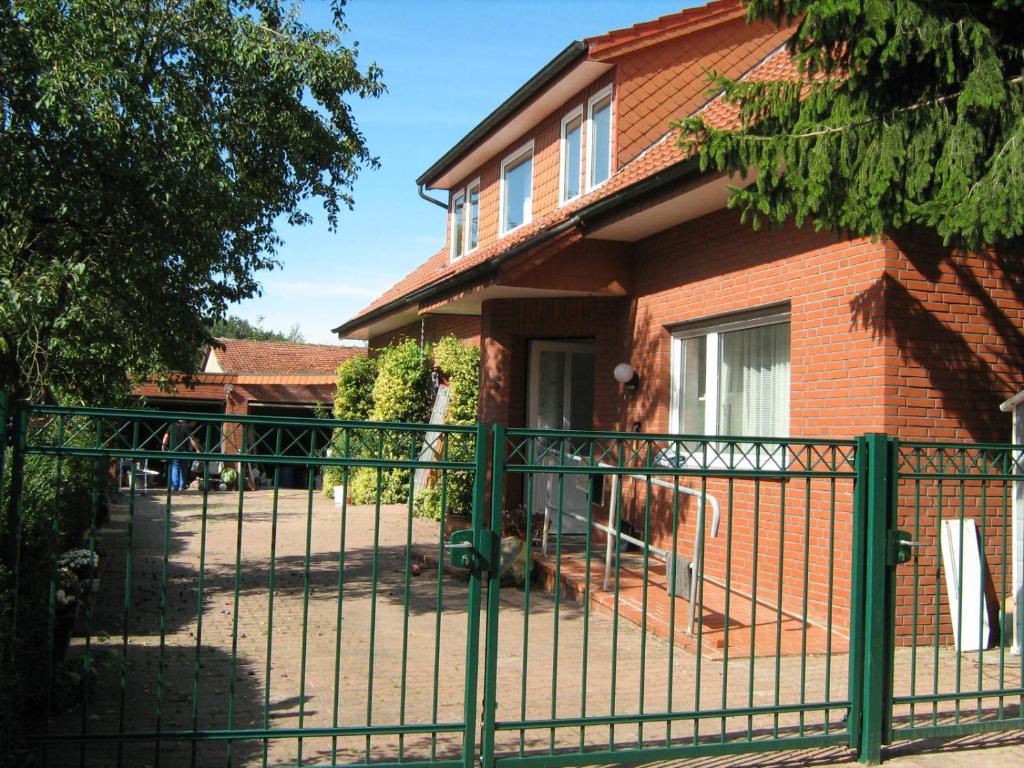 a green fence in front of a house at Ferienwohnung Alte Kämpe in Heede