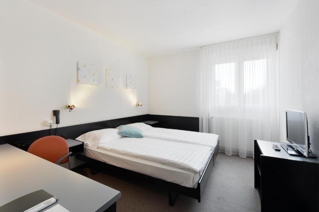Postel nebo postele na pokoji v ubytování Hôtel des Mosaiques
