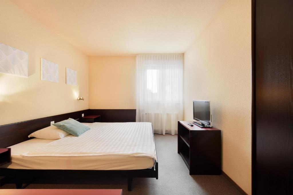 Postel nebo postele na pokoji v ubytování Hôtel des Mosaiques