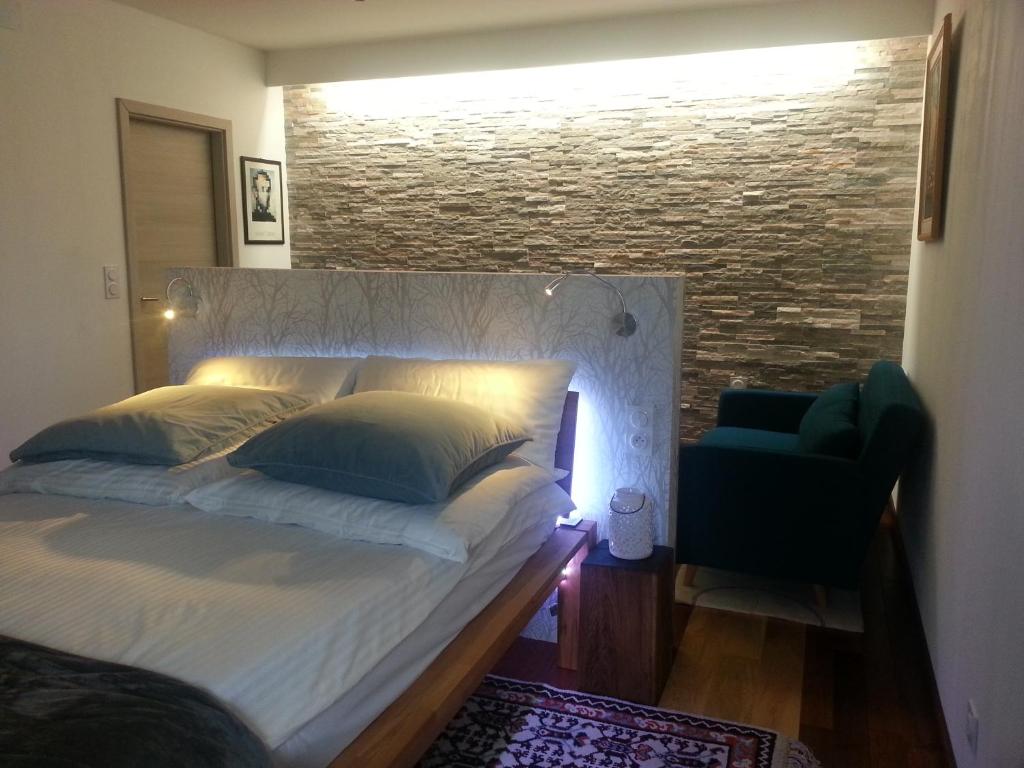 Bett in einem Zimmer mit Ziegelwand in der Unterkunft Le Gîte du Fort in Bitche