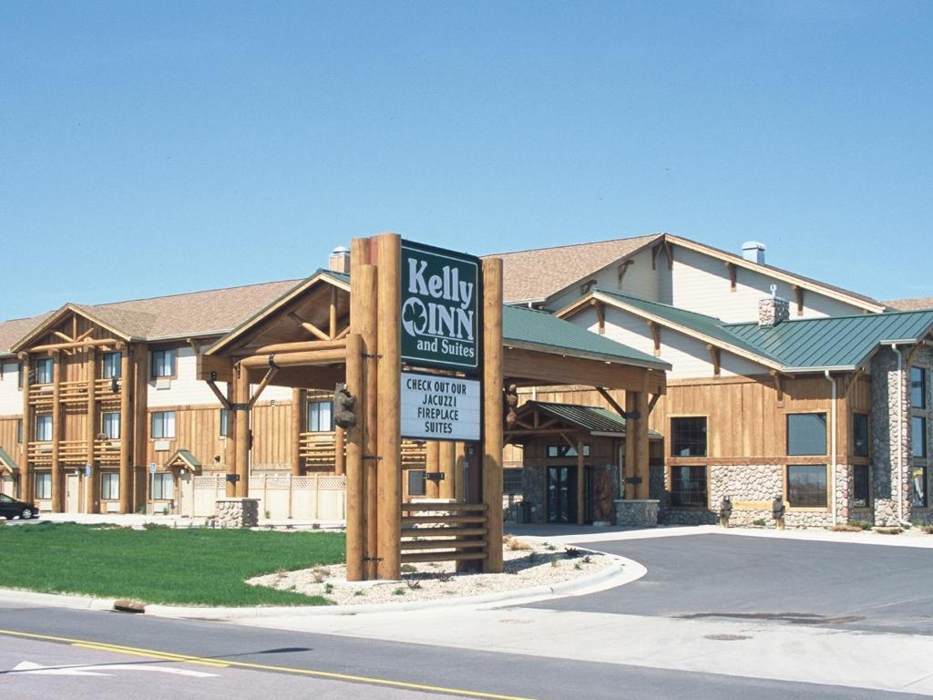 a hotel with a sign in front of a building at Kelly Inn and Suites Mitchell in Mitchell