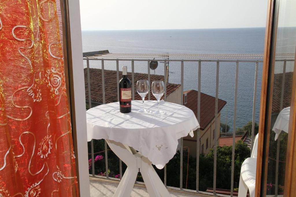 una mesa con 2 copas de vino en el balcón en DEA DEL BORGO, en SantʼAmbrogio