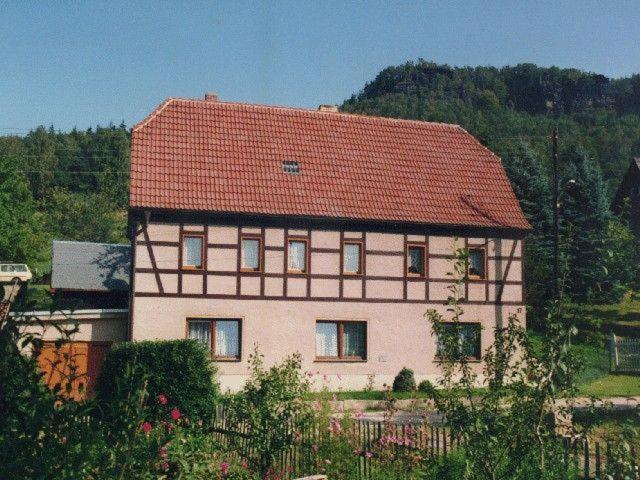 uma casa grande com telhado vermelho em Ferienwohnung-Nickl em Kleingießhübel
