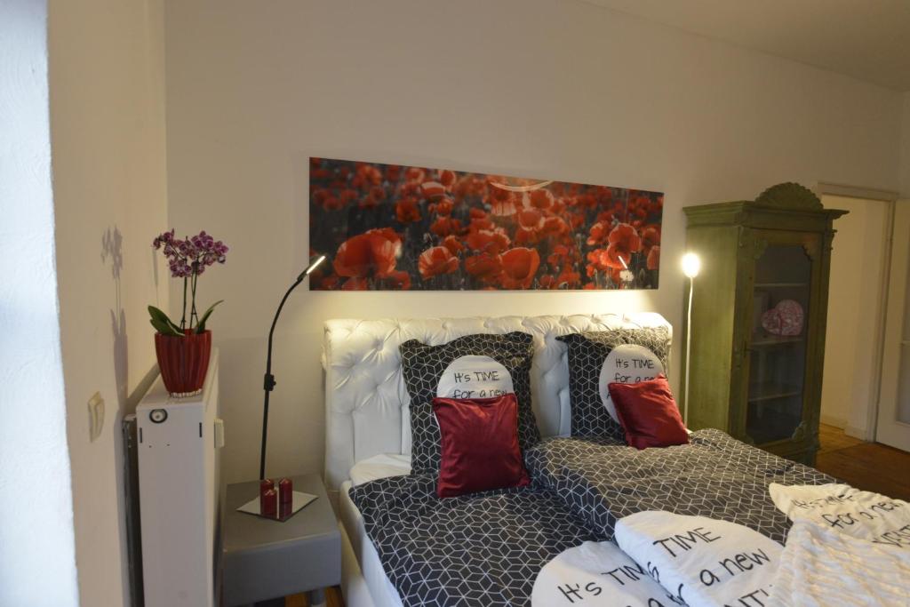 Un dormitorio con una cama con almohadas rojas y una pintura en Kaiserliche Hofpost, en Schleiden