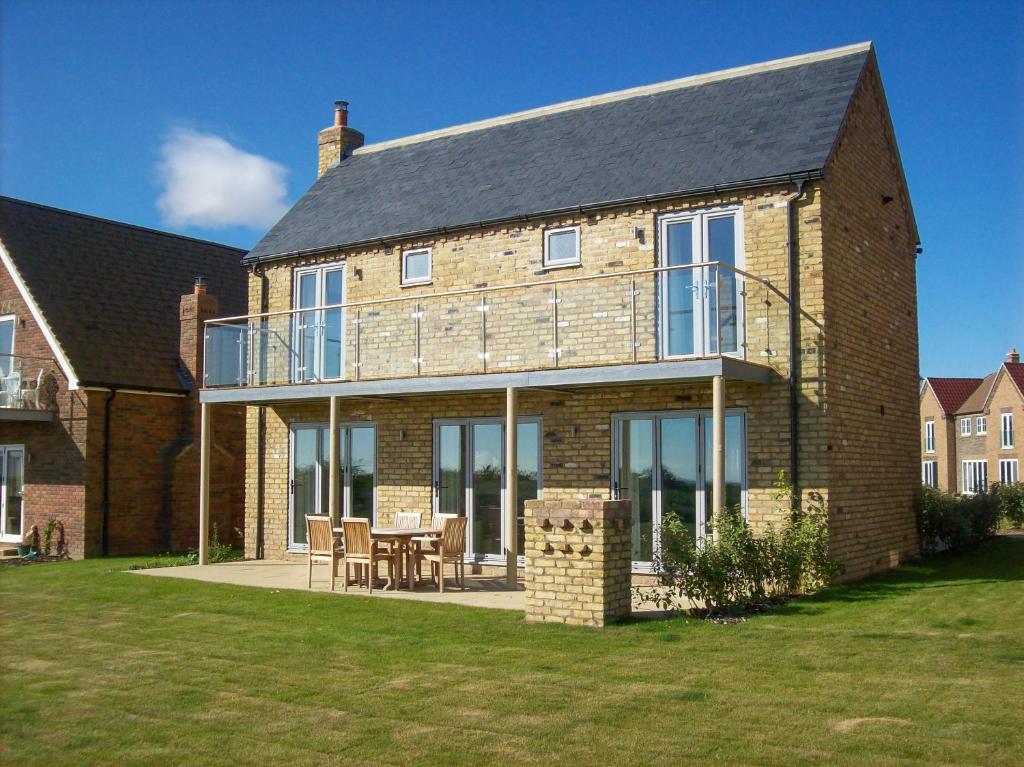 une grande maison en briques avec une table et des chaises dans l'établissement The Bay Filey, à Filey