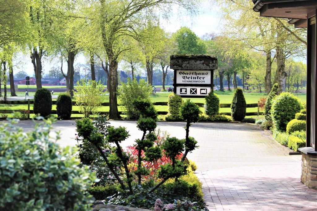 een bord in een park met bloemen en bomen bij Gasthaus Beinker in Ostercappeln