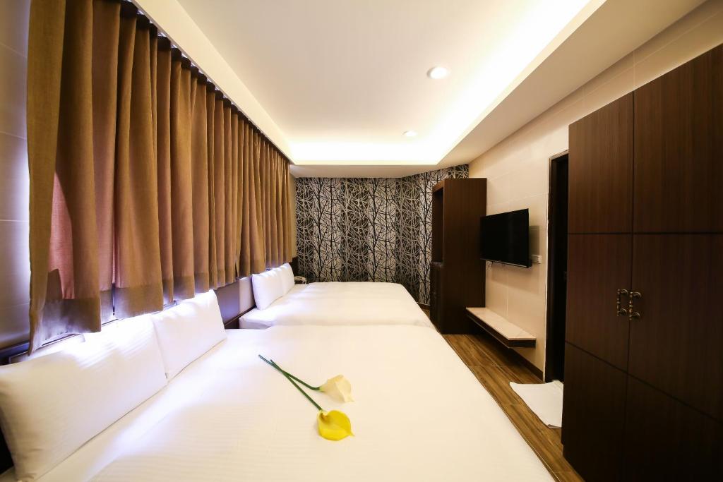 Habitación de hotel con 2 camas y TV en Maple Hotel Second Branch, en Tainan