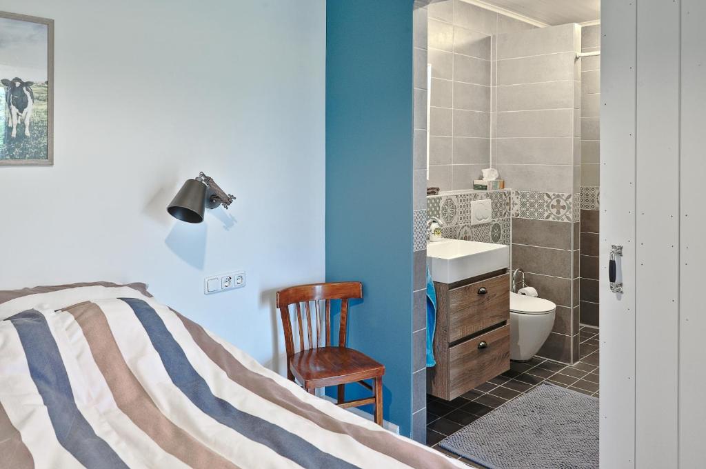 um quarto com uma cama, um lavatório e um WC em B&B d'n Uilenhof Haren em Haren