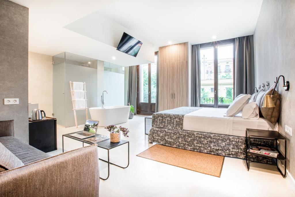 a bedroom with a bed and a living room at Casa Lirio in Barcelona