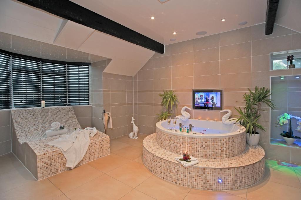 a bathroom with a tub and a tv in it at Windermere Boutique Hotel in Windermere