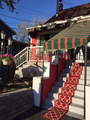a red and white building with a staircase and an umbrella at gite des iles in Matane