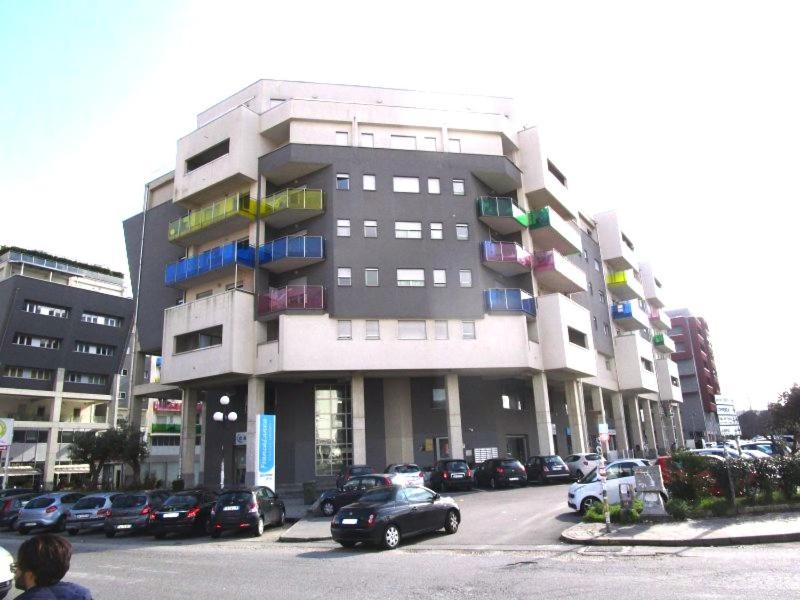 een groot gebouw met auto's geparkeerd op een parkeerplaats bij Casablanca Bed & Breakfast in Rende