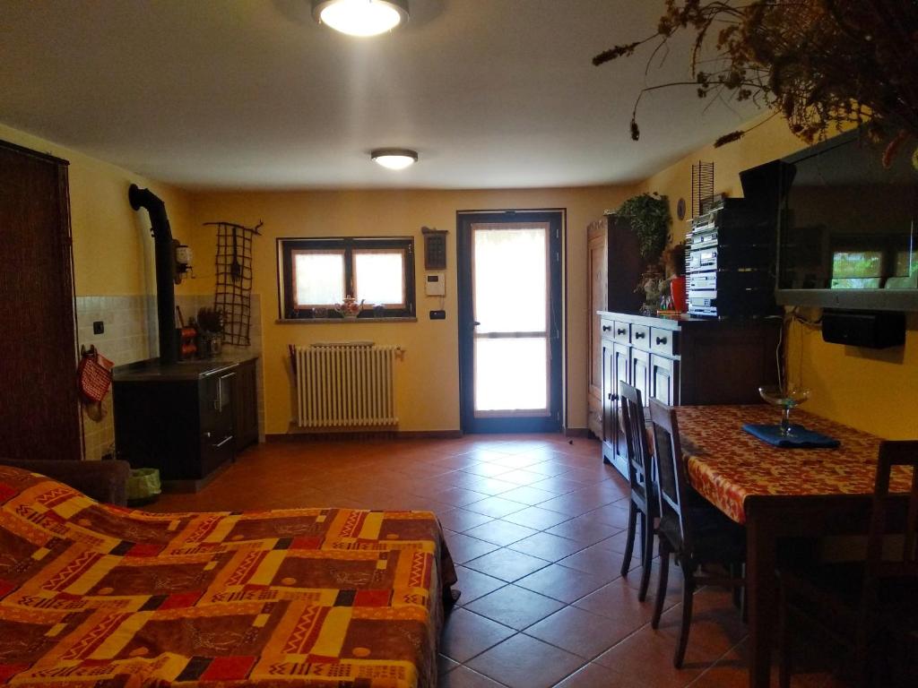um quarto com uma cozinha com uma mesa e um balcão em La Tavernetta em Torre Pellice