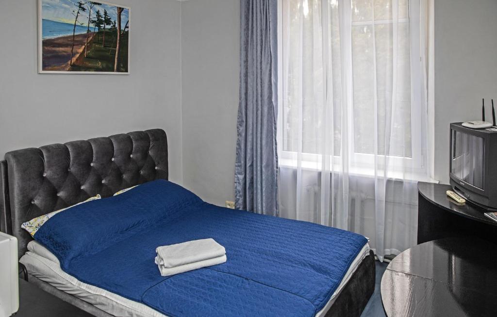 1 dormitorio con 1 cama con manta azul y TV en Vilnius Centre Flat, en Vilna