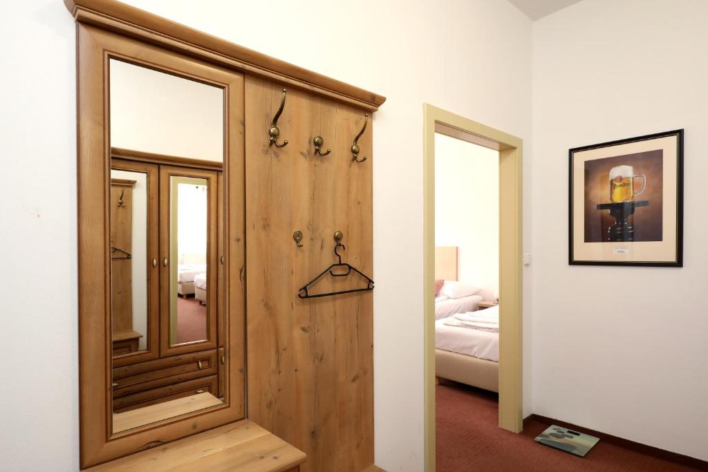 a room with a wooden door and a bedroom at Pension U Tří sedláků in České Budějovice