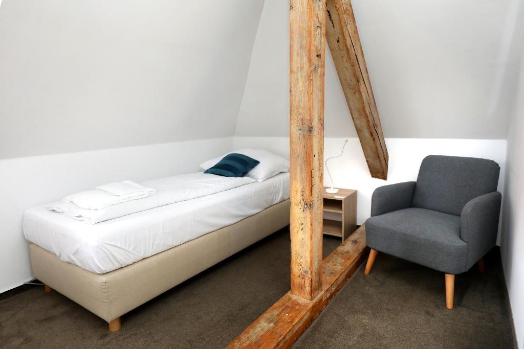 a small bedroom with a bed and a chair at Pension U Tří sedláků in České Budějovice