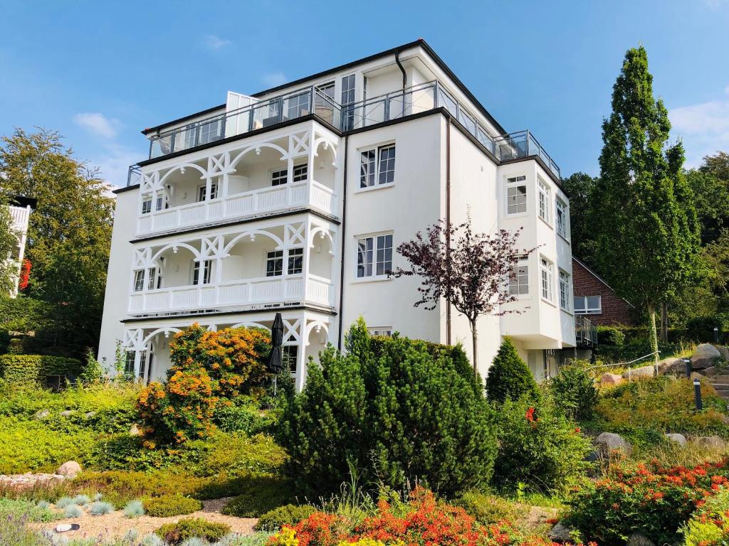 a white house with a garden in front of it at Villa Sanddorn in Binz