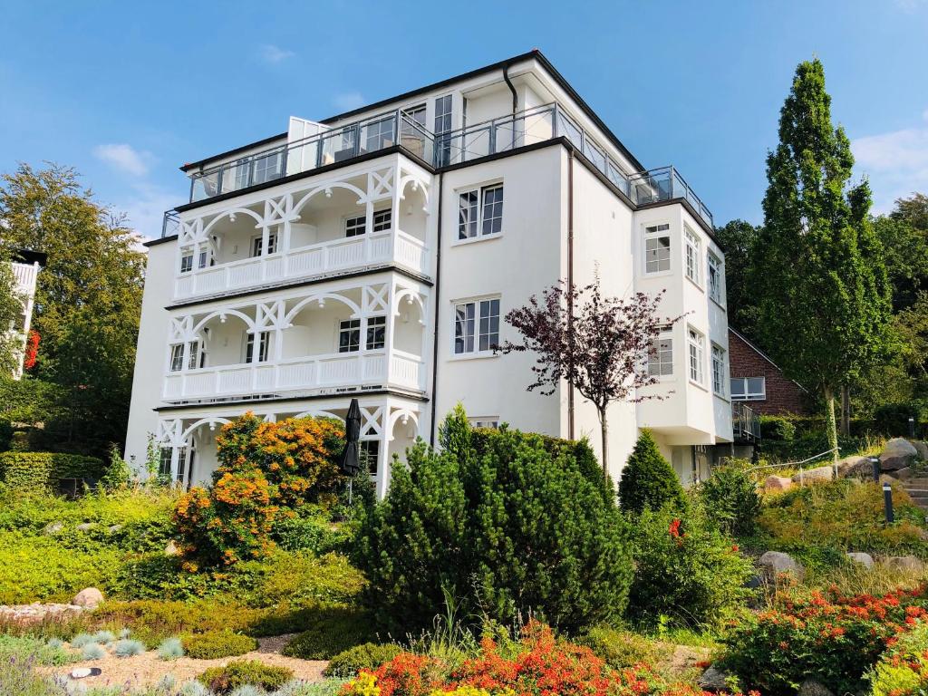 ein weißes Haus mit einem Garten davor in der Unterkunft Villa Sanddorn in Binz