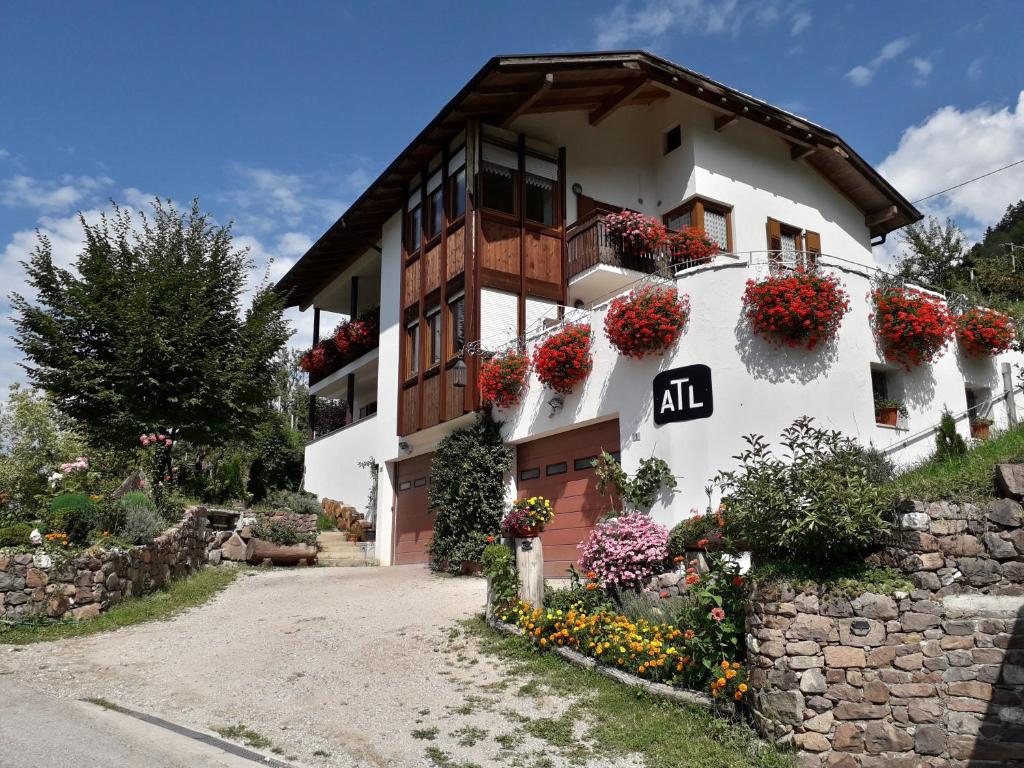 un edificio con flores a un lado. en ATL AGRITURISMO en Salorno