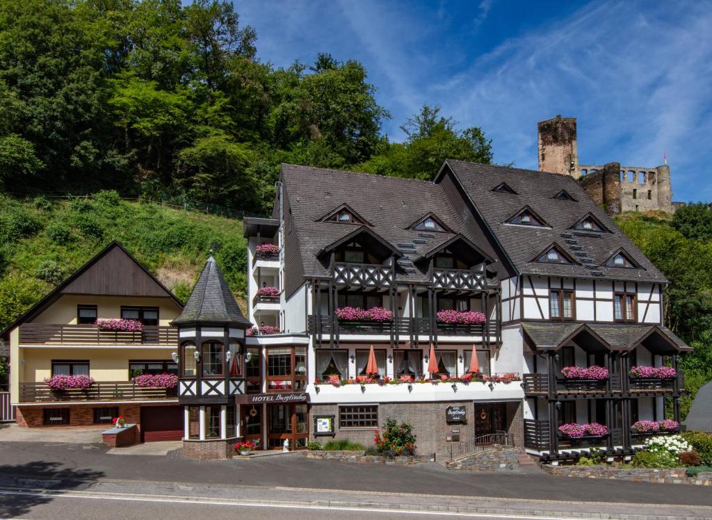 ein Haus in den Bergen mit einem Schloss im Hintergrund in der Unterkunft Hotel Burgfrieden in Beilstein