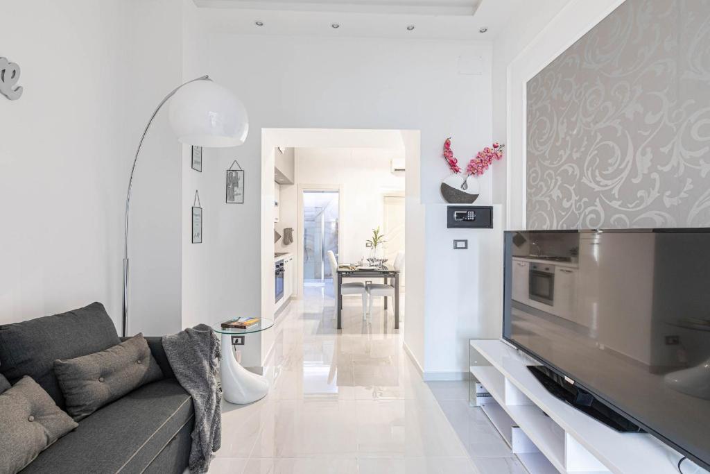 a living room with a couch and a television at Sea Elegance in Oliveri