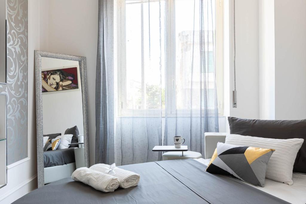 a bedroom with a bed and a mirror and a window at Sea Elegance in Oliveri