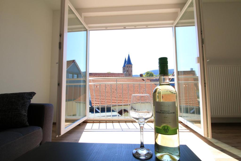 una botella de vino y una copa de vino en una mesa en Ferienwohnung Klosterblick, en Drübeck