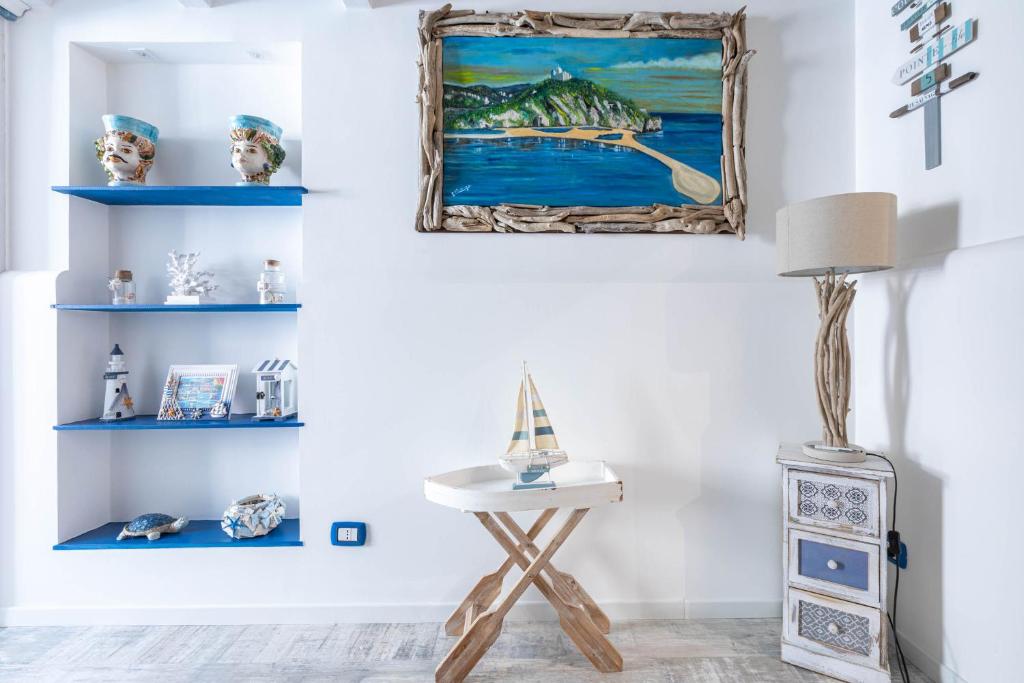 a room with blue shelves and a table with a lamp at Sea Elegance in Oliveri