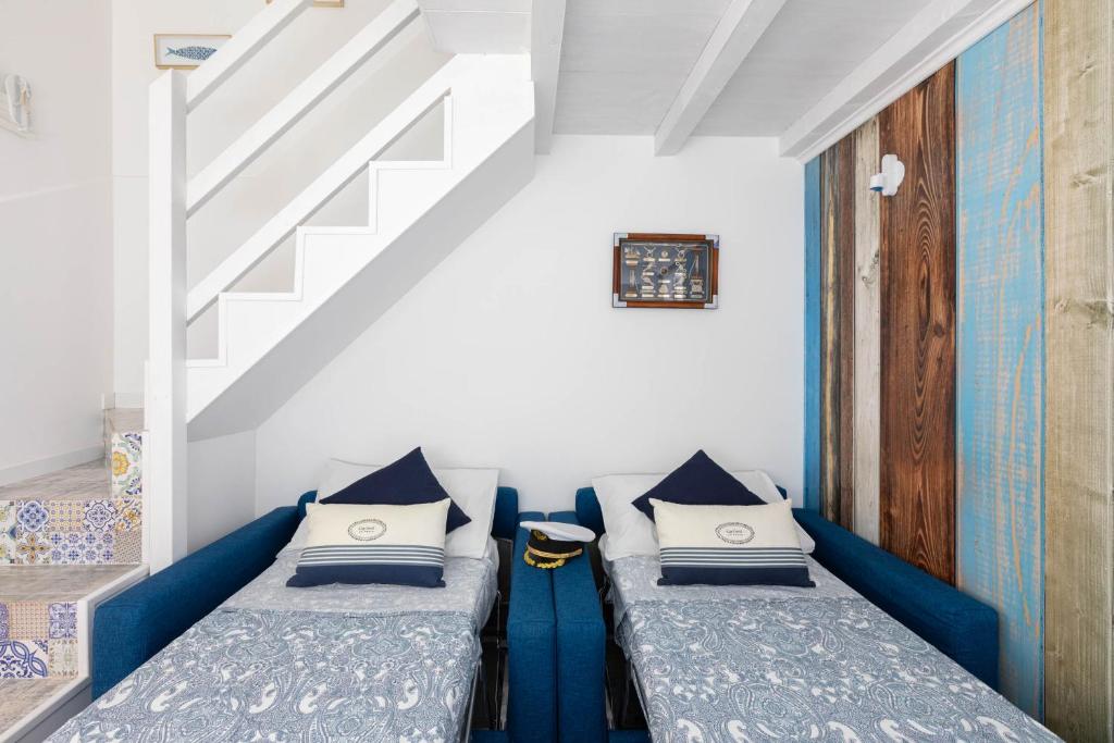 two beds in a room with a staircase at Sea Elegance in Oliveri