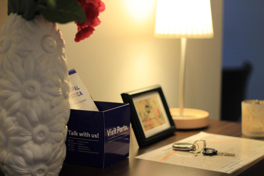 una mesa con un jarrón y una caja y una foto en Apartamento em Monsanto - Porto, en Oporto