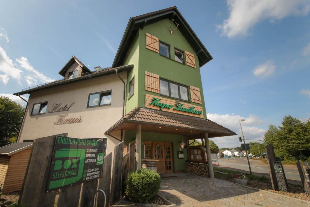 a green and white building with a store at Hotel Kraus/Heeper Landhaus in Bielefeld