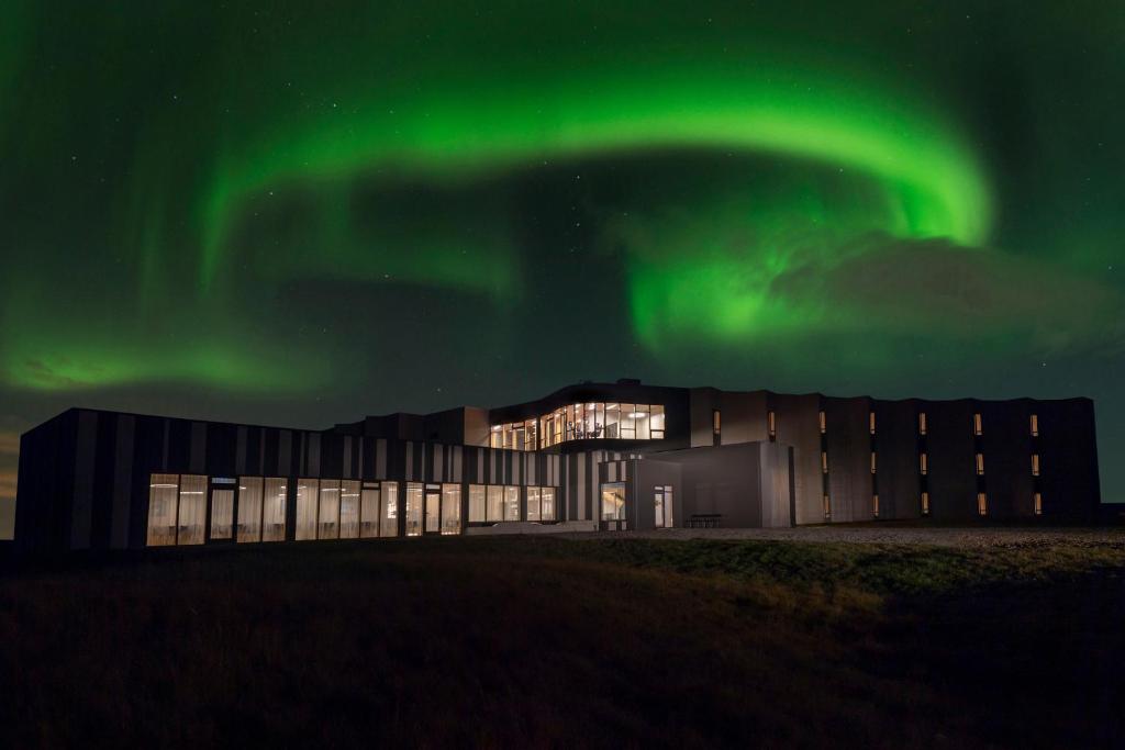 ヘトラにあるLandhotelの空中にオーロラが見えるオフィスビル