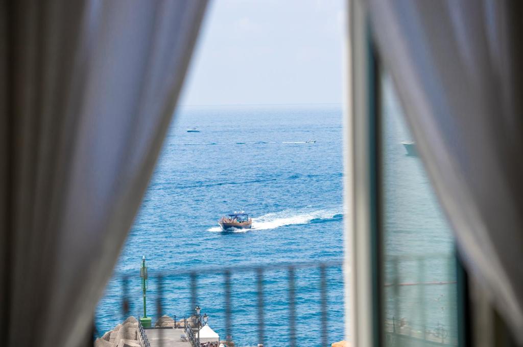 een boot in de oceaan vanuit een raam bij Amalfi Moon in Amalfi