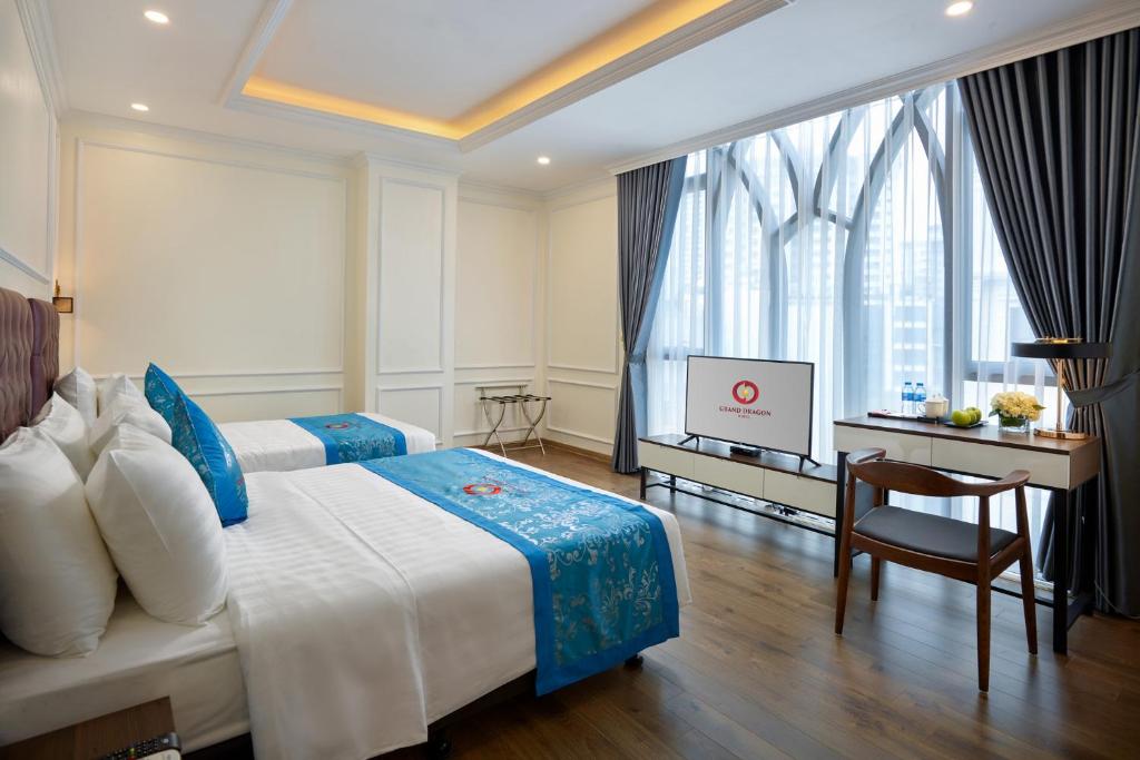 Postel nebo postele na pokoji v ubytování Grand Dragon Hotel Hanoi