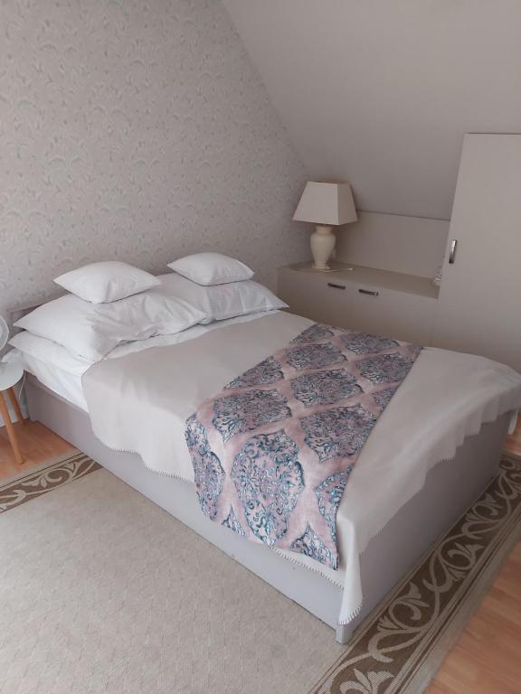 una camera da letto con un grande letto con lenzuola e cuscini bianchi di Krakowska 39 a Kazimierz Dolny