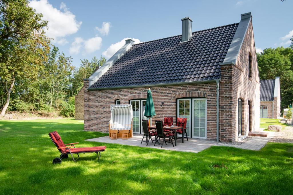 a brick house with red chairs and a patio at Fehmarn Mein Urlaub in Fehmarn