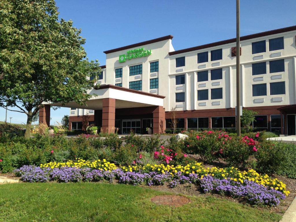 a hotel with flowers in front of it at Wyndham Garden Elk Grove Village - O'Hare in Elk Grove Village
