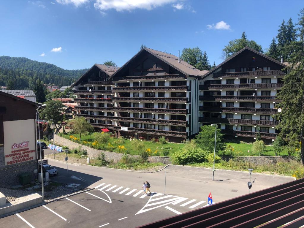 a large building with a parking lot in front of it at Ski Terrace Heaven Partia Clabucet in Predeal