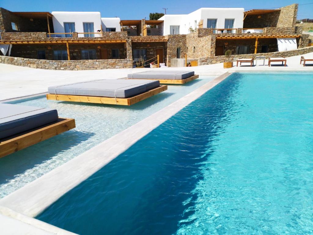 a swimming pool with blue water in a resort at Myconian Crown Suites in Kalafatis