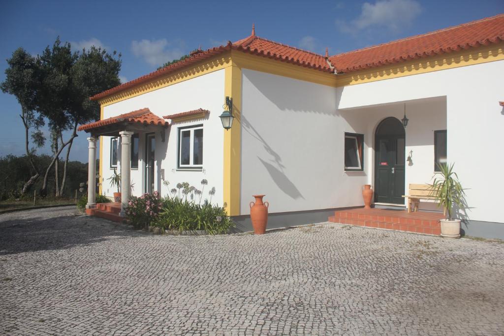 uma pequena casa branca com um telhado vermelho em Vagos Art.Lab em Vagos